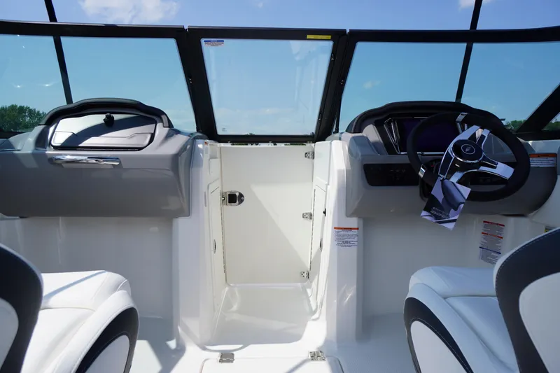 Slide: The Image of Interior view of 2026 Chaparral 21 SSi OB boat cockpit with steering wheel and seating. - 21