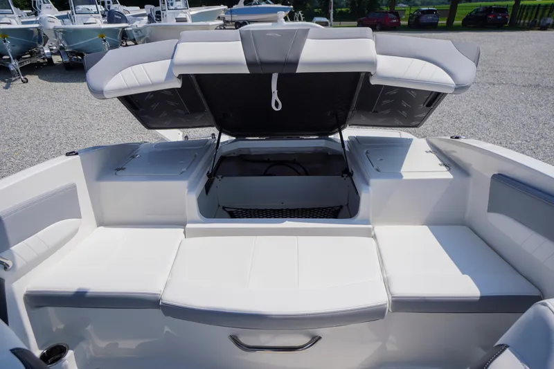 Slide: The Image of 2026 Chaparral 21 SSi OB boat interior with open storage compartment and cushioned seating. - 32