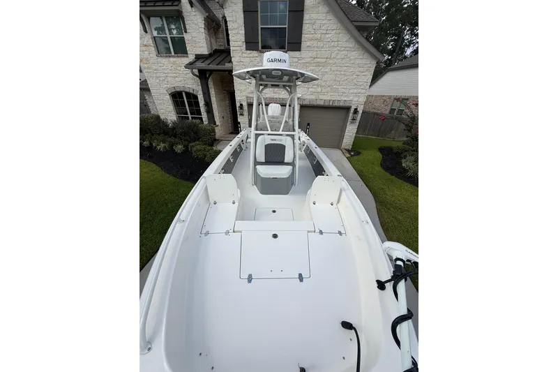 Slide: The Image of 2024 Pathfinder 2600 TRS boat parked in front of a modern house. - 9