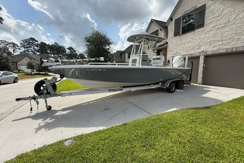The Image of 2024 Pathfinder 2600 TRS boat on trailer in residential driveway, sunny day. - 1