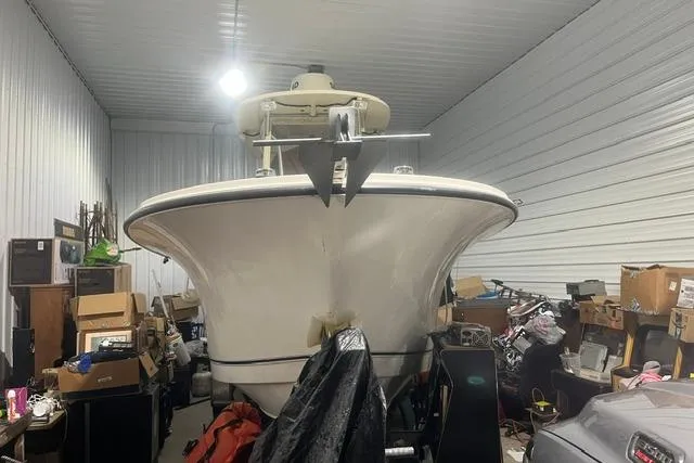 Slide: The Image of 2005 Trophy 2502 Pro boat stored indoors, surrounded by boxes and equipment. - 5