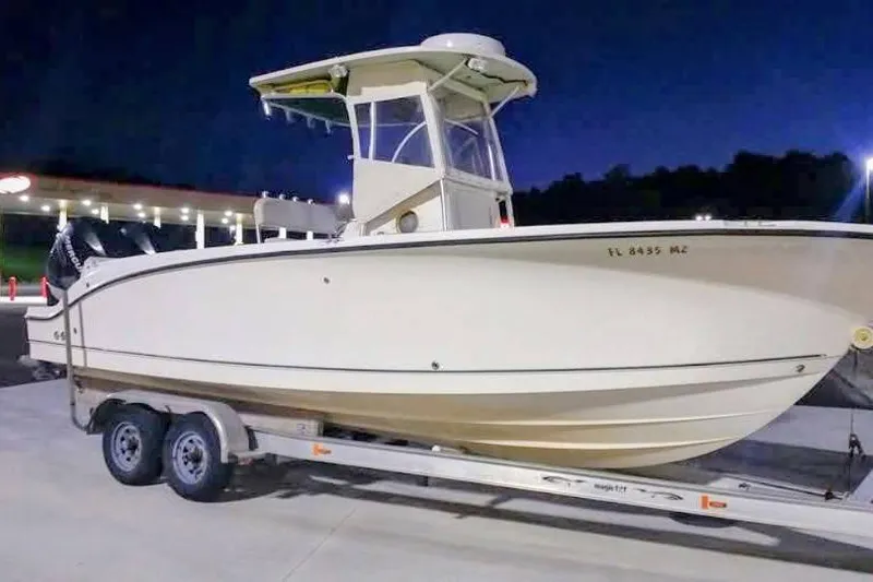Slide: The Image of 2005 Trophy 2502 Pro boat on trailer at night, parked near a gas station. - 1