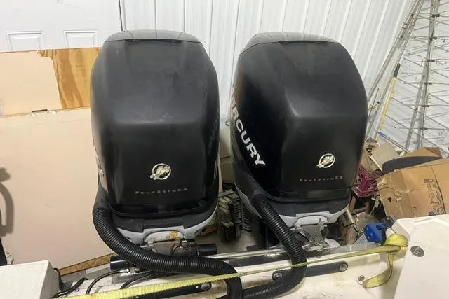 Slide: The Image of Twin Mercury outboard engines on a 2005 Trophy 2502 Pro boat in a storage area. - 12