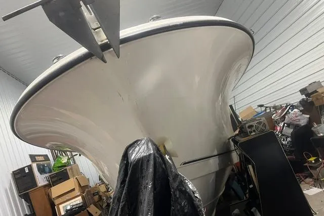 Slide: The Image of 2005 Trophy 2502 Pro boat stored indoors, surrounded by various items. - 6