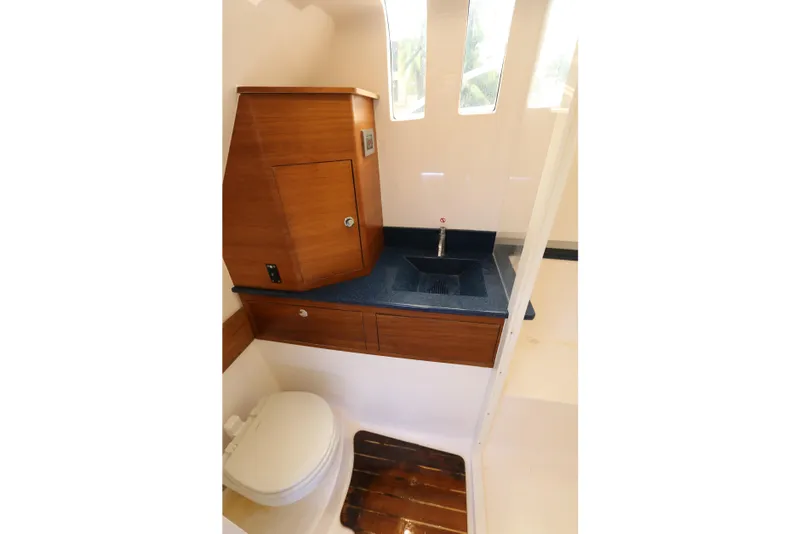 Slide: The Image of 2018 Belzona 327 Walkaround boat bathroom with wooden cabinetry and modern sink design. - 7