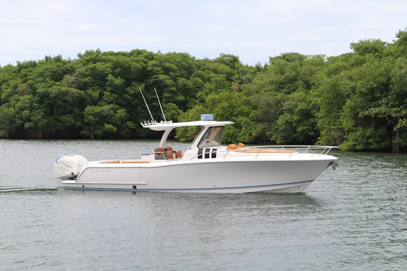 Slide: The Image of 2018 Belzona 327 Walkaround boat cruising on a serene lake with lush green trees. - 18