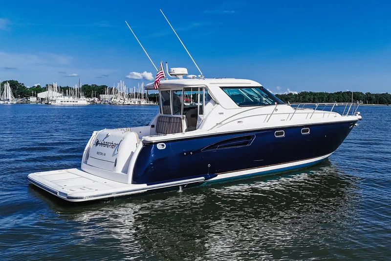 The Image of 2004 Tiara Yachts 4400 Sovran cruising on a serene lake under a clear blue sky. - 0