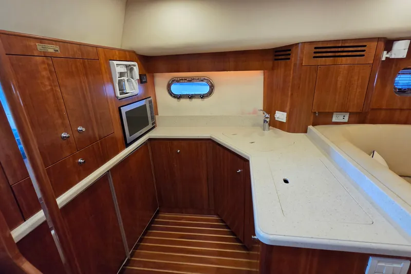 Slide: The Image of Luxurious 2004 Tiara Yachts 4400 Sovran galley with wood cabinetry and modern appliances. - 31