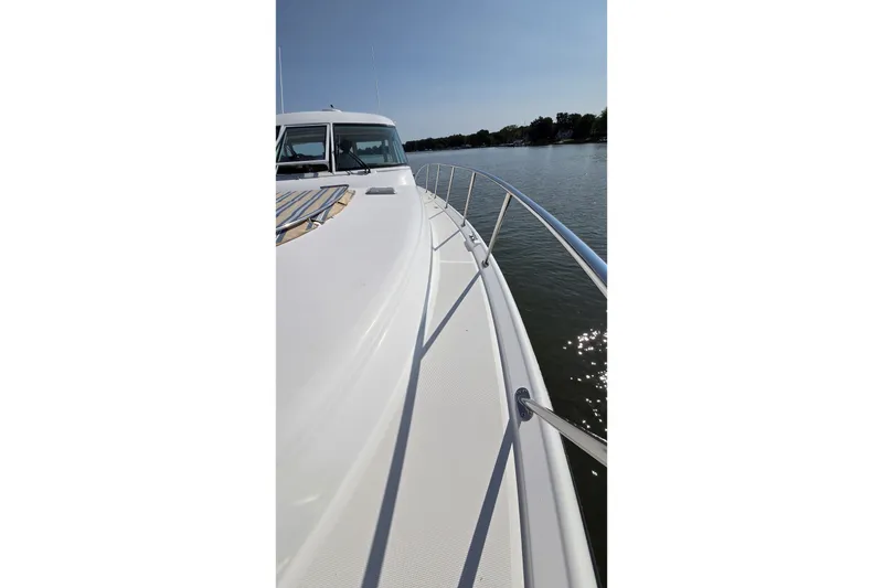 Slide: The Image of 2004 Tiara Yachts 4400 Sovran on calm water, showcasing sleek deck design. - 10