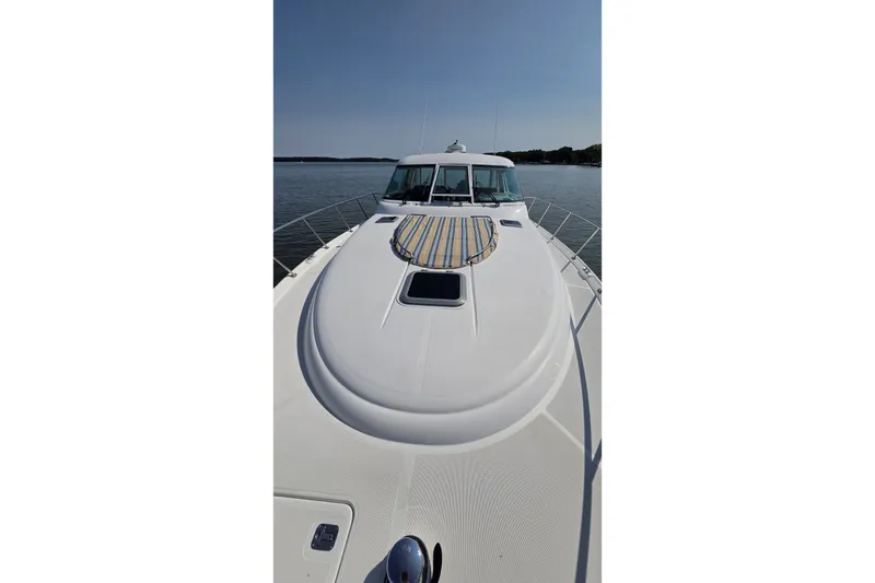 Slide: The Image of 2004 Tiara Yachts 4400 Sovran on calm water, showcasing sleek deck design. - 9