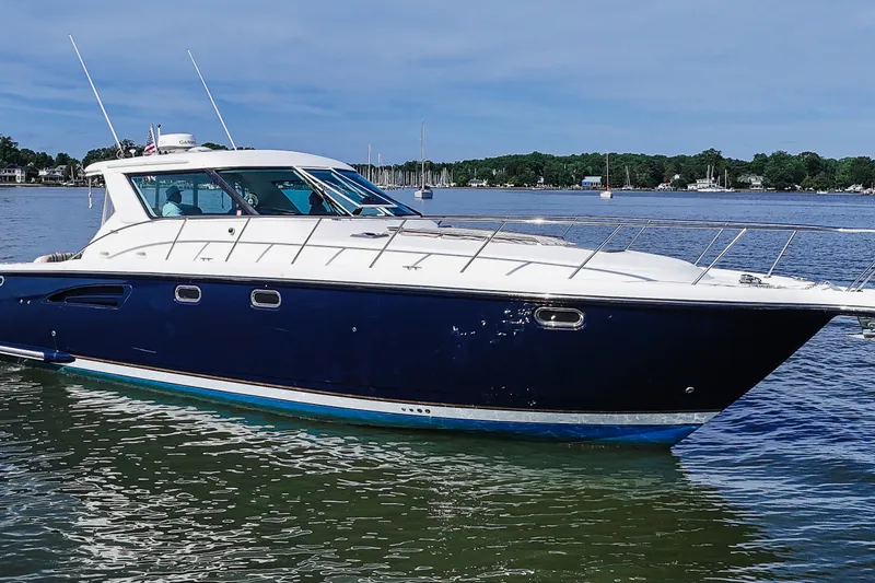 Slide: The Image of 2004 Tiara Yachts 4400 Sovran cruising on a serene lake under a clear sky. - 1