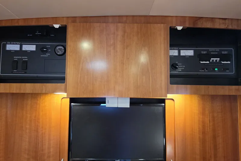 Slide: The Image of Control panel of a 2004 Tiara Yachts 4400 Sovran, featuring wood cabinetry. - 30
