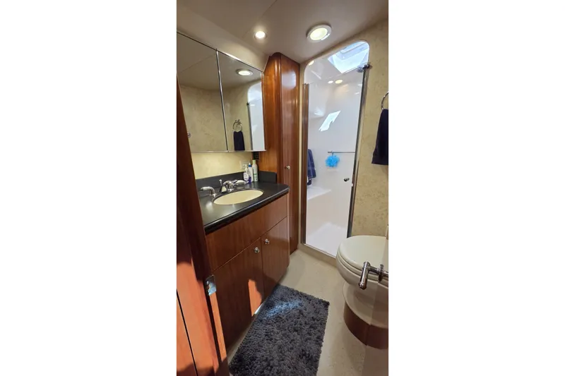 Slide: The Image of Luxurious 2004 Tiara Yachts 4400 Sovran bathroom with modern fixtures and elegant wood cabinetry. - 36