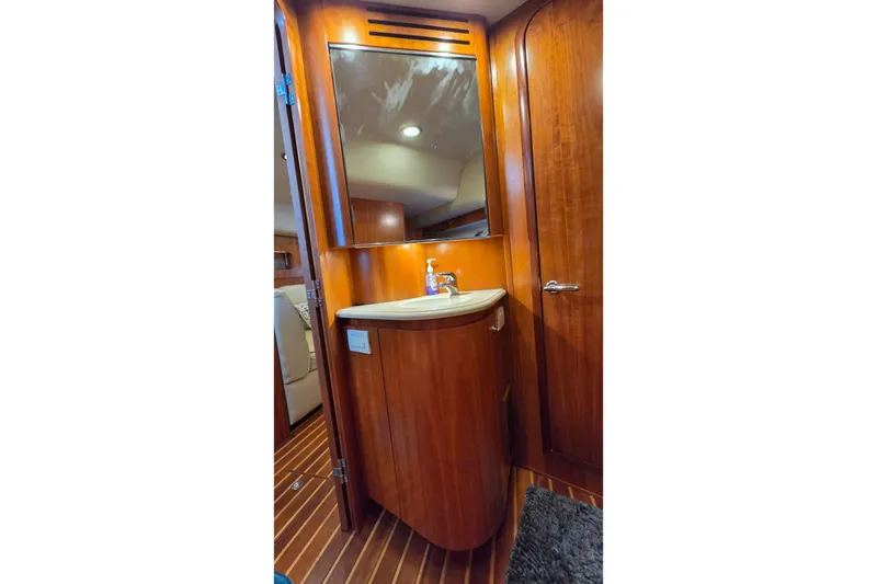 Slide: The Image of Luxurious wooden bathroom interior of 2004 Tiara Yachts 4400 Sovran with sink and mirror. - 38