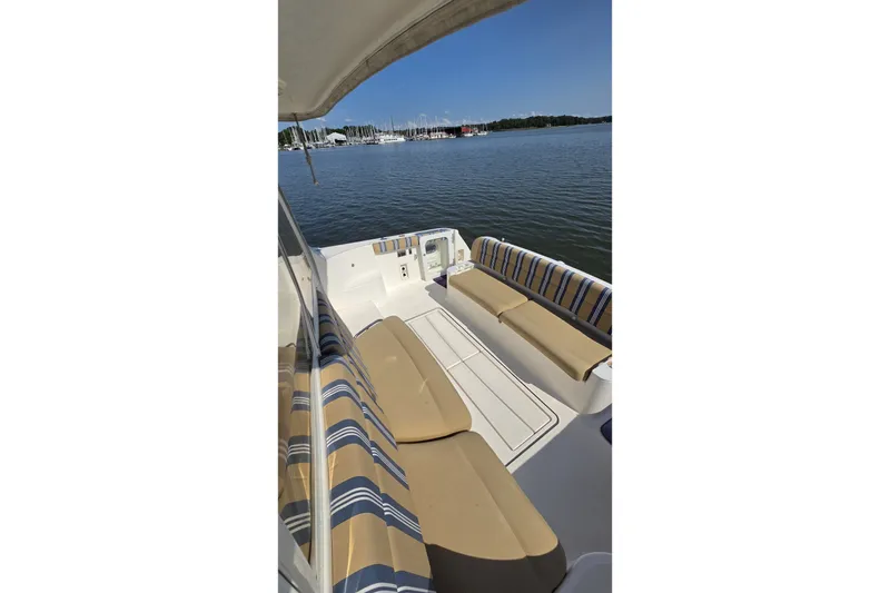 Slide: The Image of 2004 Tiara Yachts 4400 Sovran deck with striped seating, overlooking calm waters. - 18