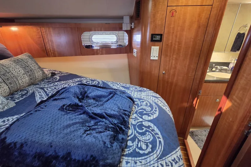 Slide: The Image of Luxurious cabin interior of 2004 Tiara Yachts 4400 Sovran with elegant bedding and wood finish. - 35