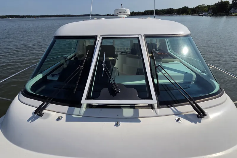 Slide: The Image of 2004 Tiara Yachts 4400 Sovran with windshield wipers, docked on calm water. - 12