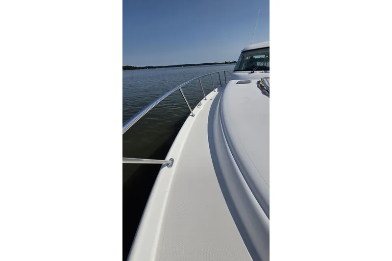 Slide: The Image of 2004 Tiara Yachts 4400 Sovran cruising on calm waters under clear skies. - 11
