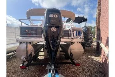 Slide: The Image of 2023 Sun Tracker Bass Buggy 18 DLX pontoon boat with 60 HP engine, parked outdoors. - 8