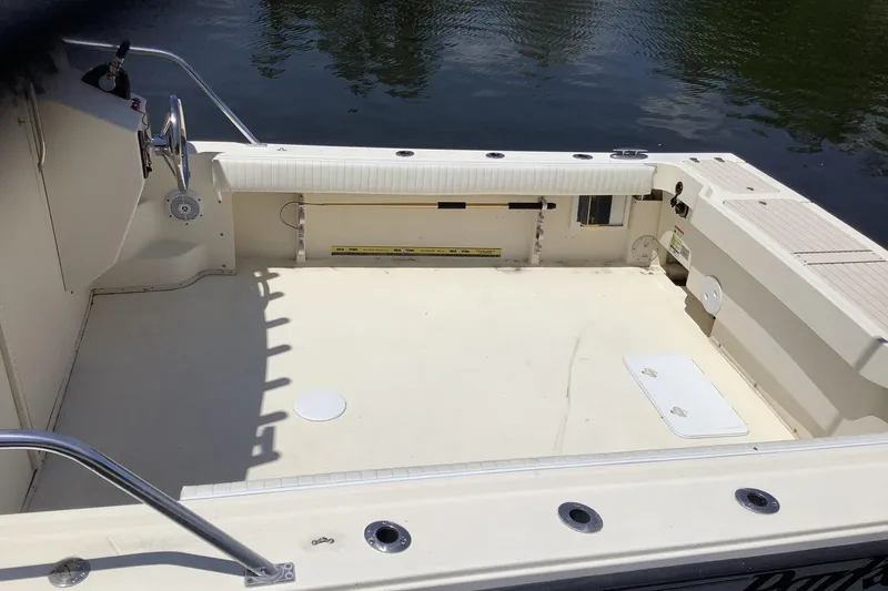 Slide: The Image of 2012 Parker 2520 XL Sport Cabin boat deck, spacious and clean, near water. - 4