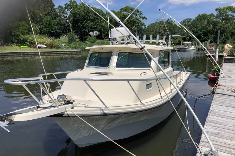 The Image of 2012 Parker 2520 XL Sport Cabin boat docked on a calm river. - 0