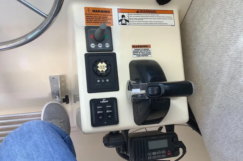 Slide: The Image of Control panel of a 2012 Parker 2520 XL Sport Cabin boat with throttle and warning labels. - 10