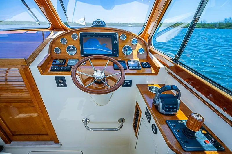 Slide: The Image of Helm of 2013 Hinckley Talaria 34 yacht with wooden dashboard and navigation equipment. - 11