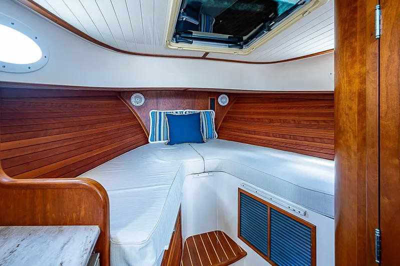 Slide: The Image of Interior cabin of 2013 Hinckley Talaria 34 with wooden paneling and cozy bedding. - 14