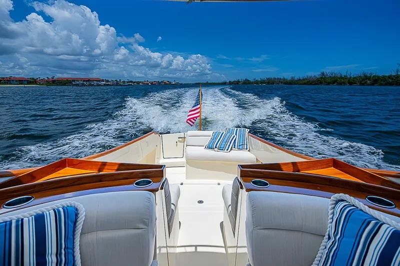 Slide: The Image of Hinckley Talaria 34 cruising on open water, showcasing luxury seating and American flag. - 5