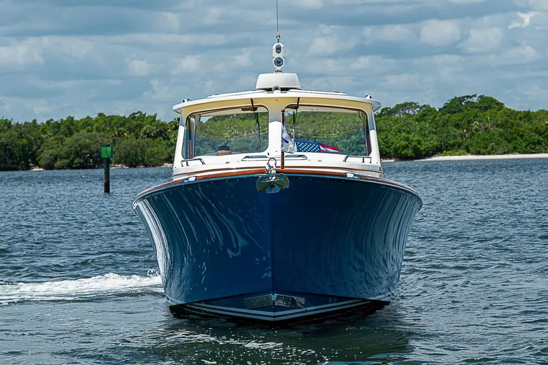 Slide: The Image of 2013 Hinckley Talaria 34 cruising on a scenic waterway under a partly cloudy sky. - 2