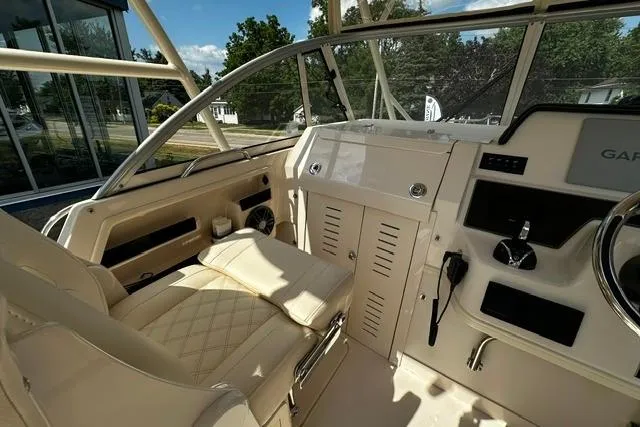 Slide: The Image of 2025 Grady-White Gulfstream 232 boat interior with beige seating and modern dashboard controls. - 33
