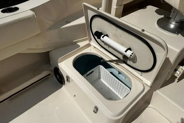 Slide: The Image of Open storage compartment on 2025 Grady-White Gulfstream 232 boat, featuring a white basket inside. - 22
