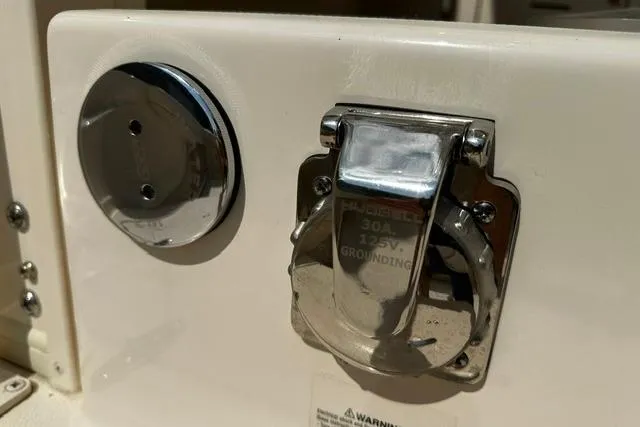 Slide: The Image of 2025 Grady-White Gulfstream 232 boat power outlet and grounding plug detail. - 23
