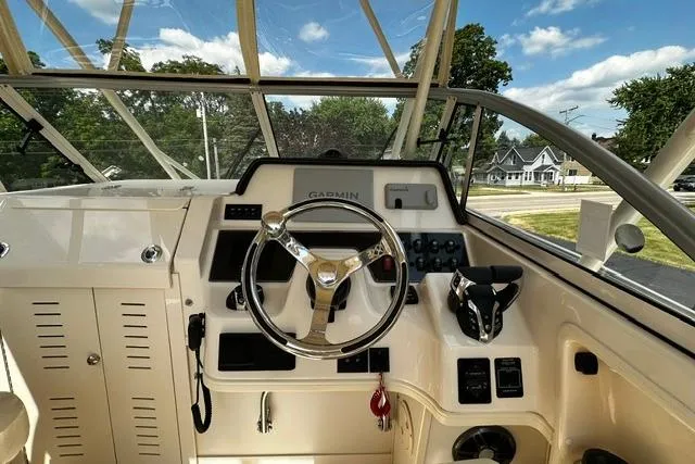 Slide: The Image of 2025 Grady-White Gulfstream 232 boat cockpit with steering wheel and Garmin navigation system. - 26
