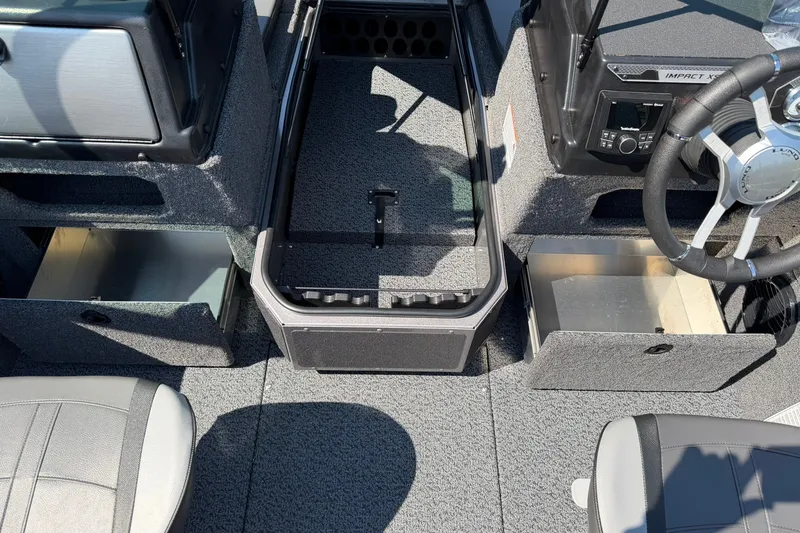 Slide: The Image of 2027 Lund 1875 Impact XS Sport boat interior with storage compartments and steering wheel. - 7