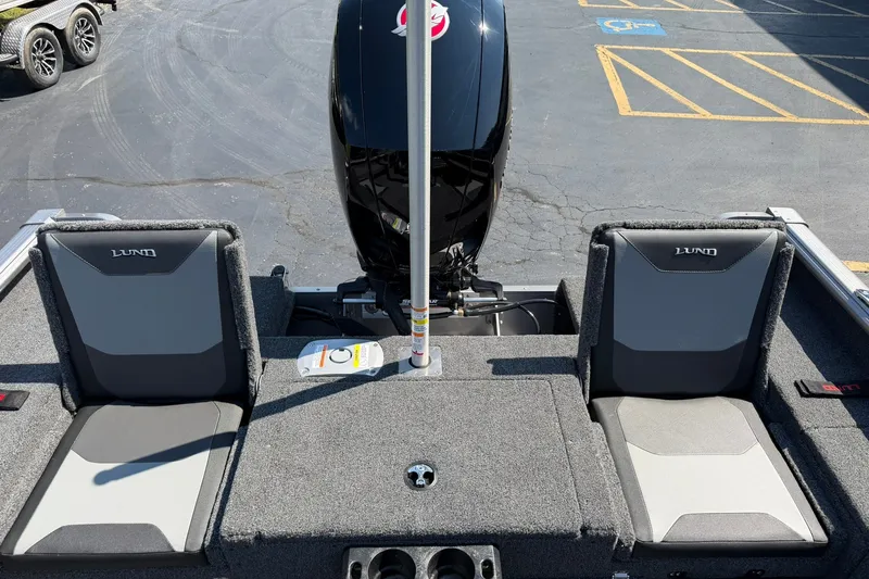 Slide: The Image of 2027 Lund 1875 Impact XS Sport boat interior with dual seats and motor view. - 10