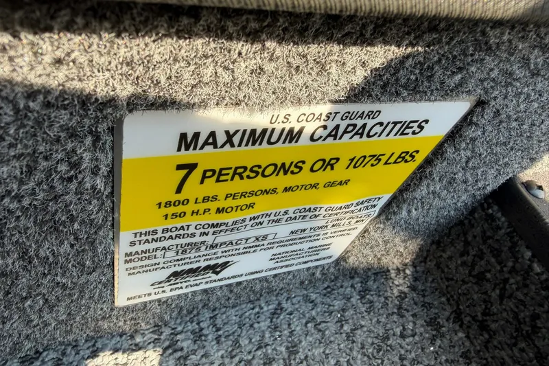 Slide: The Image of Capacity label on 2027 Lund 1875 Impact XS Sport boat, indicating 7 persons or 1075 lbs limit. - 22