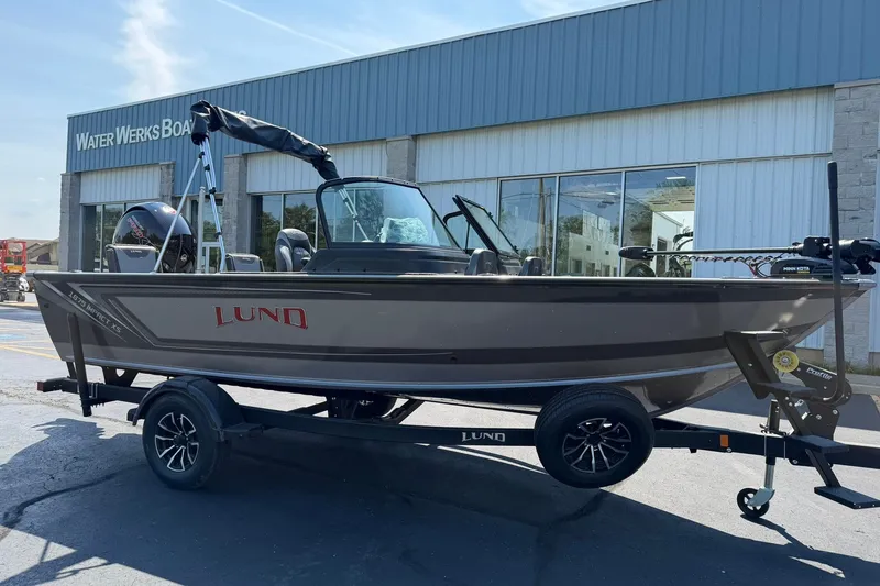 Slide: The Image of 2027 Lund 1875 Impact XS Sport boat on trailer outside dealership. - 1