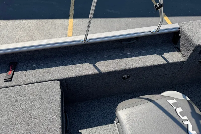 Slide: The Image of Interior of 2027 Lund 1875 Impact XS Sport boat, featuring gray seating and carpet. - 19