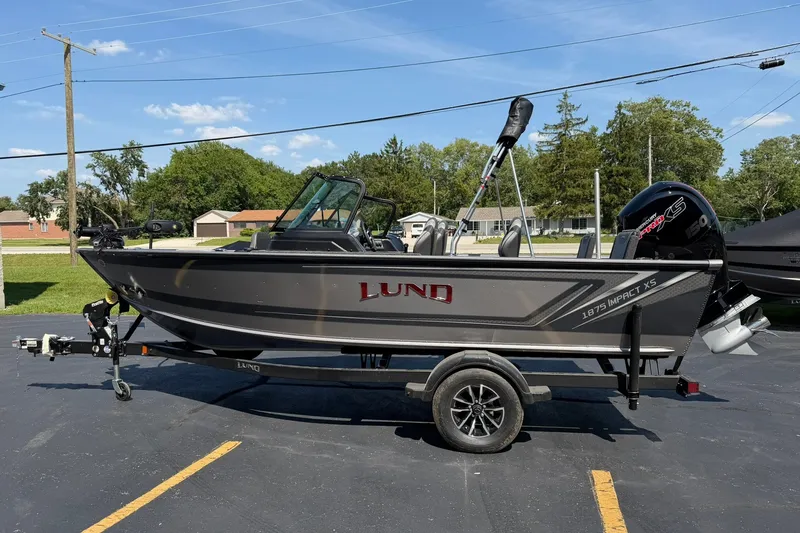 Slide: The Image of 2027 Lund 1875 Impact XS Sport boat on trailer, parked outdoors. - 3