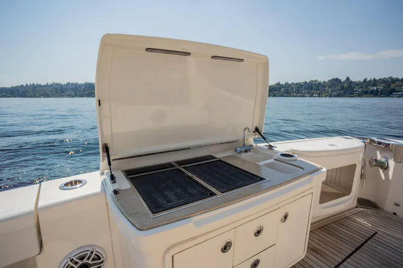 Slide: The Image of Outdoor grill on 2012 Riviera 33 Flybridge yacht, overlooking serene lake view. - 29