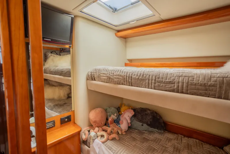 Slide: The Image of Cozy cabin interior of 2012 Riviera 33 Flybridge with bunk beds and plush toys. - 18