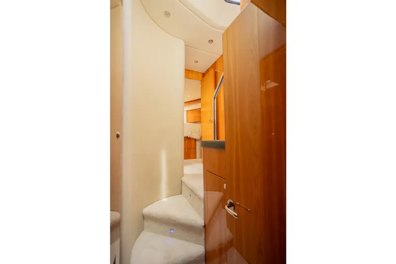 Slide: The Image of Interior view of 2012 Riviera 33 Flybridge yacht with wooden finishes and carpeted stairs. - 19