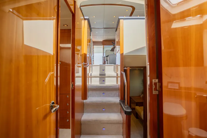 Slide: The Image of Luxurious interior of 2012 Riviera 33 Flybridge yacht with polished wood and carpeted stairs. - 8