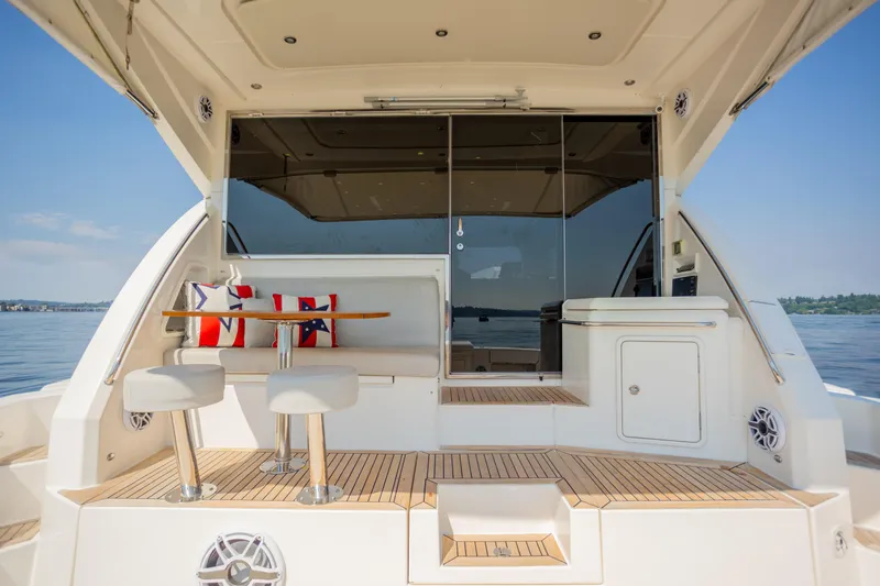 Slide: The Image of 2012 Riviera 33 Flybridge yacht interior with seating, table, and scenic water view. - 25