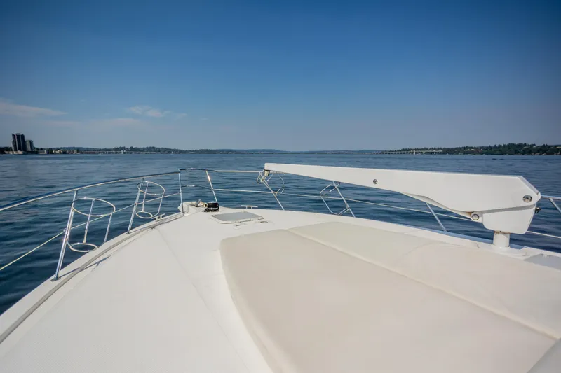 Slide: The Image of Bow view of 2012 Riviera 33 Flybridge yacht on calm waters under clear sky. - 32