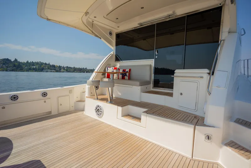 Slide: The Image of Luxurious 2012 Riviera 33 Flybridge yacht deck with seating, overlooking serene waters. - 26