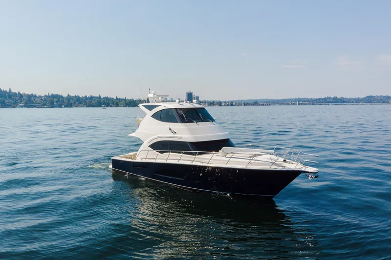 Slide: The Image of 2012 Riviera 33 Flybridge yacht cruising on a calm lake under clear skies. - 36