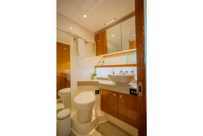 Slide: The Image of Luxurious bathroom in 2012 Riviera 33 Flybridge yacht with modern fixtures and elegant wood cabinetry. - 15