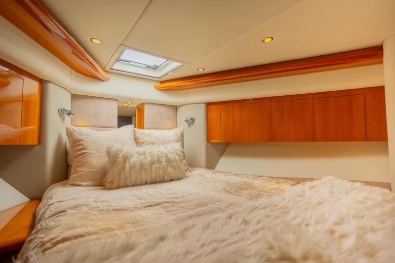 Slide: The Image of Luxurious bedroom interior of 2012 Riviera 33 Flybridge yacht with plush bedding and wood accents. - 10